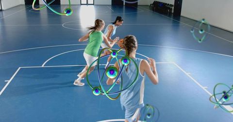 Female basketball players sprinting on indoor court with floating 3d atom overlays