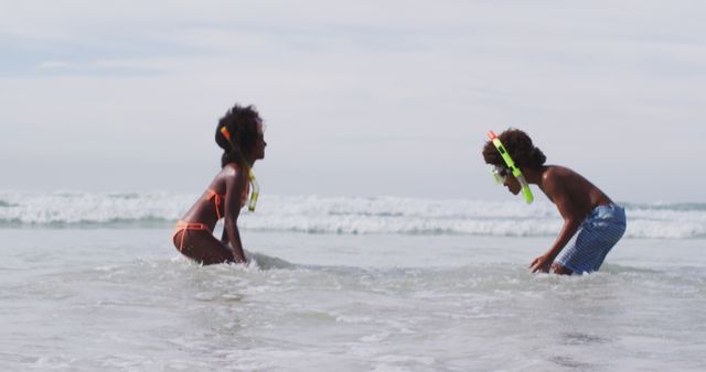 African american children wearing scuba goggles playing at the beach. healthy outdoor leisure time by the sea.