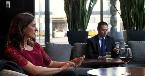 Business Professionals Using Devices in Modern Hotel Lounge