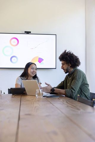 Diverse Team Analyzing Business Data in Contemporary Conference Room