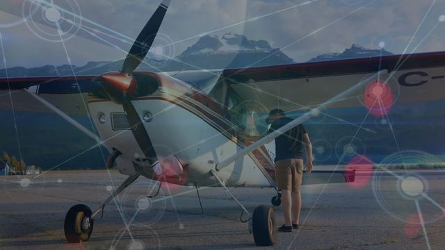 A man is seen preparing a small airplane, with an overlay of digital network connections highlighting global business and technological advancements. This video is perfect for illustrating concepts related to aviation, modern technology in aviation, network connections in global business, and the future of travel with interconnected systems.