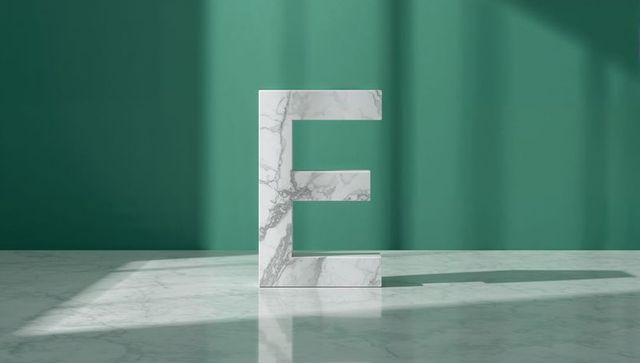 Marble Letter E Standing Tall in Sunlit Teal Room