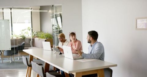 Modern Team Collaboration in Office with Laptops and Discussion - Download Free Stock Images Pikwizard.com