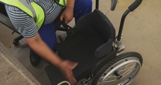 Man Adjusting Wheelchair Seat in Workshop Setting - Download Free Stock Images Pikwizard.com