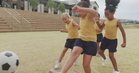 Energetic Children Playing Soccer on School Field