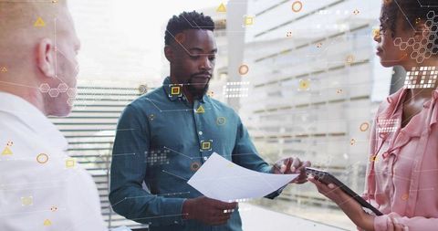 Business team reviewing analytics document in modern office with digital data overlay