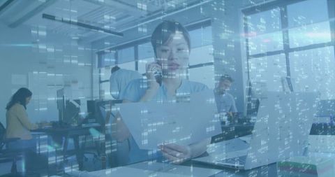 Businesswoman Discussing Documents on Phone in Modern Office Environment