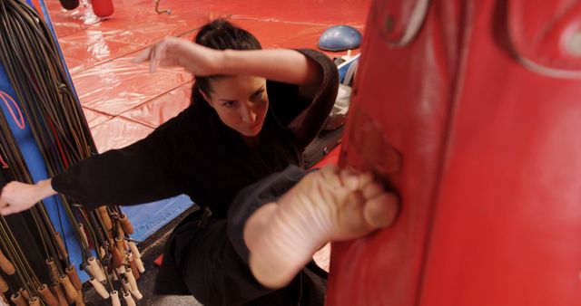 Karate player kicking a boxing bag in fitness studio - Download Free Stock Photos Pikwizard.com