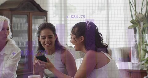 Multigenerational women sharing smartphone, laughing together in cozy living room