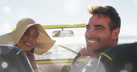 Smiling Couple Driving Convertible on Scenic Beach Day