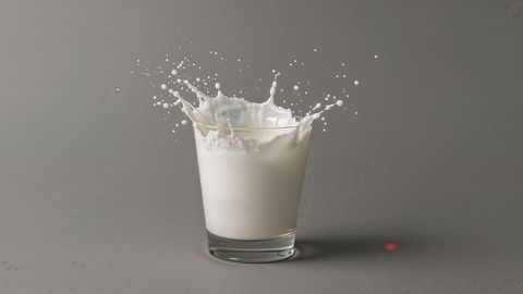 Milk Splashing in Glass on Grey Background