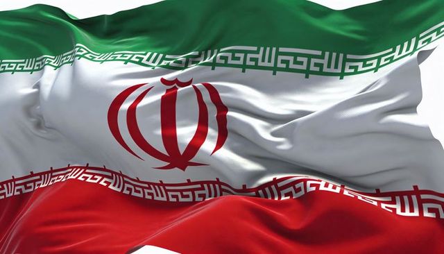 Waving iranian flag close-up showing satin texture, central red emblem and kufic border