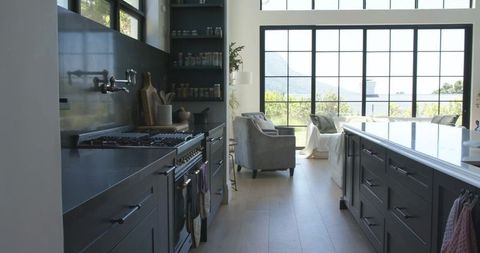 Modern Open-Plan Kitchen Featuring Dark Gray Shaker Cabinets, White Island and Lakeview