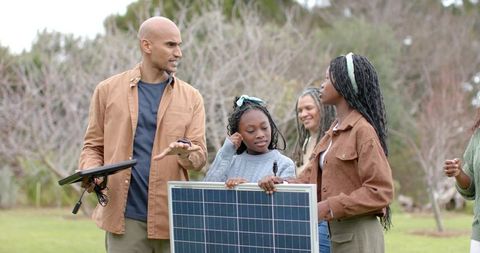 Multigenerational family learning solar power in orchard for renewable energy education