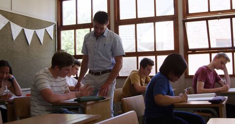 Teacher Assisting Engaged High School Students During Classroom Activity - Download Free Stock Images Pikwizard.com