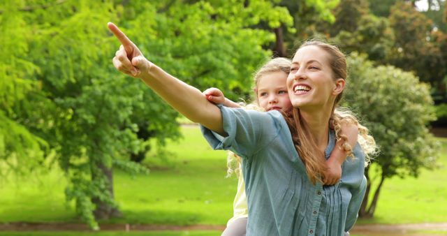 Happy Young Mother with Daughter Pointing in Park - Download Free Stock Images Pikwizard.com