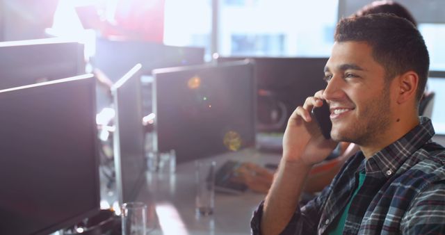 Smiling Young Professional Talking on Phone in Modern Office - Download Free Stock Images Pikwizard.com