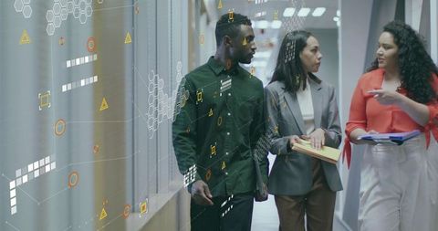 Business Team Analyzing Data While Walking in Office Hallway