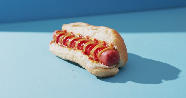 Image of hot dog with mustard and ketchup on a blue surface. food, cuisine and catering ingredients.