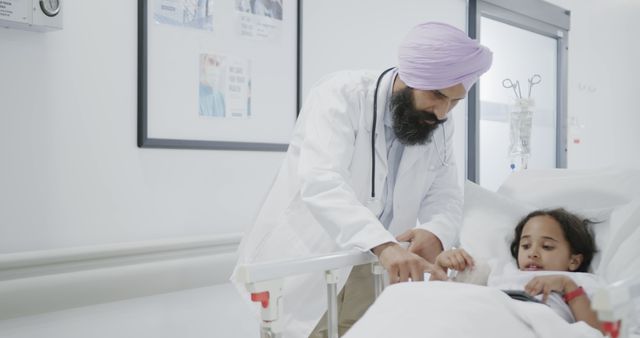 Sikh Doctor Caring for Young Patient in Hospital Bed - Download Free Stock Images Pikwizard.com