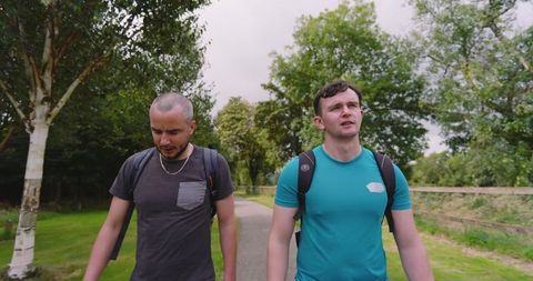 Two friends hiking in park enjoying nature and conversation