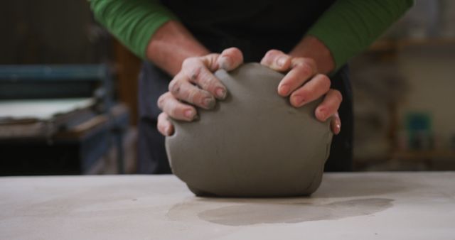 Close up view of male potter kneading the clay at pottery studio - Download Free Stock Photos Pikwizard.com