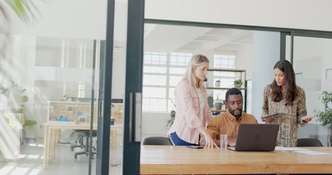 Diverse Team Collaborating on Project in Modern Office Environment