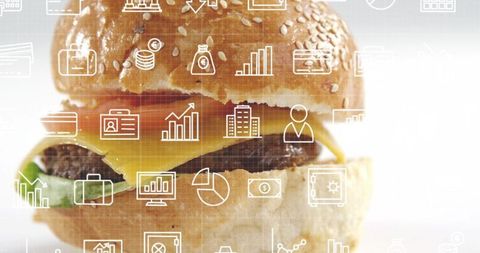 Sesame bun cheeseburger with melted cheddar and financial icon overlay for business