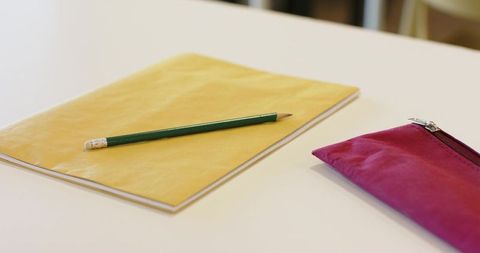Minimal Yellow Notebook with Green Pencil and Magenta Pencil Case on Clean White Table