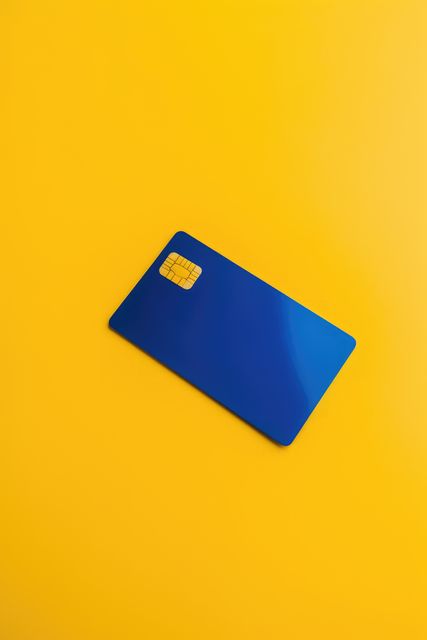 Blank blue credit card with microchip on yellow, copy space, created using generative ai technology. Emv chip, banking, spending, technology and finance mock up concept digitally generated image.