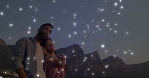 Romantic couple starlit sky gazing over mountain ridge at twilight