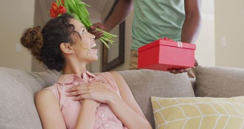 Surprised Woman Receiving Gift and Flowers from Partner