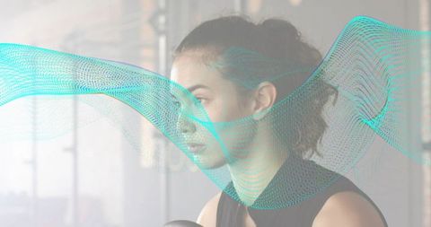 Resting young woman holding fitness ball with turquoise digital wave overlay