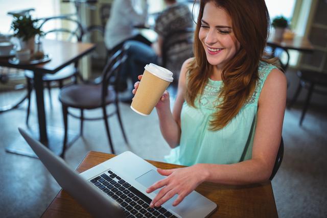 Smiling woman using digital tablet while having a coffee in cafe