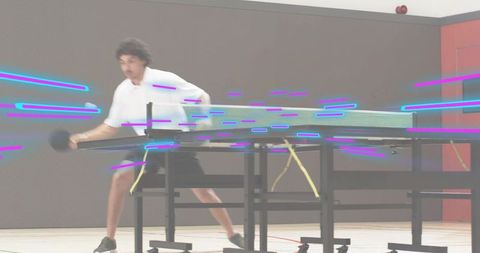 Table tennis player lunging with paddle in gymnasium showing speed and dynamic motion