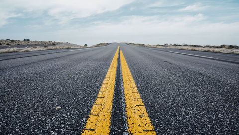 Stretching empty desert highway with leading double yellow lines and open horizon