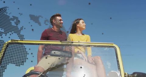 Couple enjoying summer road trip in yellow convertible under clear blue sky