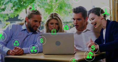 Business team collaborating over laptop with green sustainability and finance icons overlay