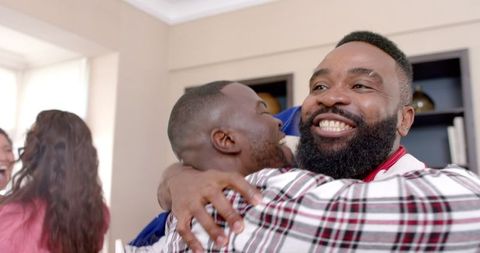 Joyful multiethnic friends celebrating with american flag indoors
