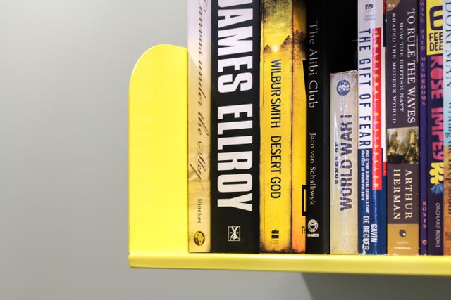 Close-Up of Books on a Yellow Bookshelf - Download Free Stock Photos Pikwizard.com