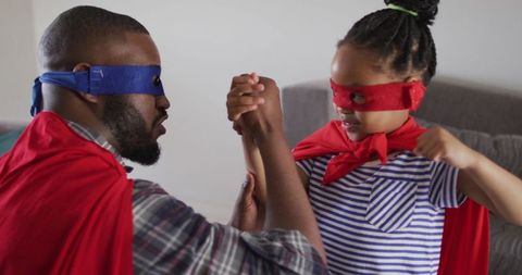 Father and daughter enjoying quality time in superhero costumes