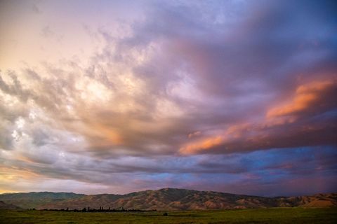 Vibrant Sunset Clouds Over Rolling Hills