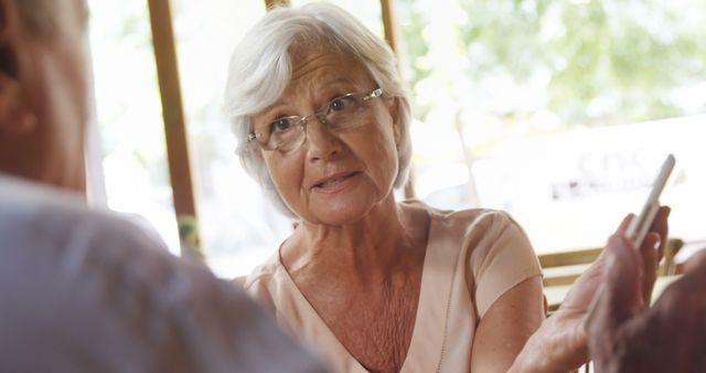 Senior Woman Having Serious Conversation at Outdoor Cafe - Download Free Stock Images Pikwizard.com