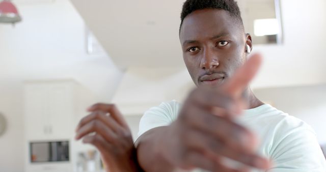 Young African American Man Stretching Indoors with Earbuds - Download Free Stock Images Pikwizard.com