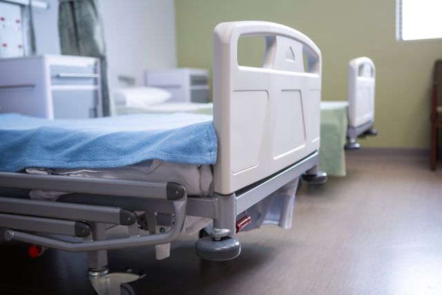 Empty hospital beds in a clean and sterile ward. Ideal for use in healthcare, medical, and hospital-related content, showcasing patient care facilities, recovery rooms, and clinical environments.