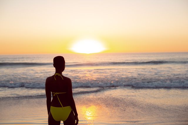 Thoughtful woman in bikini standing on the beach - Download Free Stock Photos Pikwizard.com