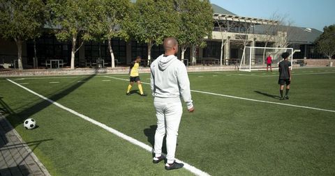 Soccer coach observing players on outdoor field