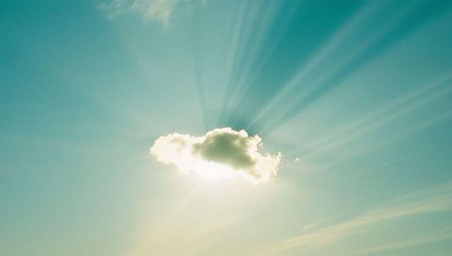 Sunbeams Radiating Behind Single Cumulus Cloud