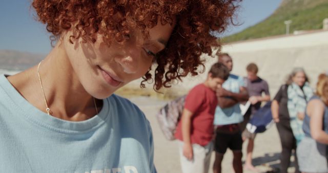 Woman Volunteering at Beach Cleanup with Diverse Group - Download Free Stock Images Pikwizard.com