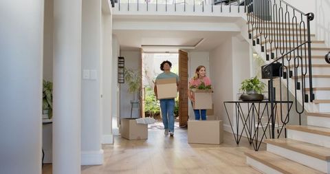 Joyful couple moving into new home with moving boxes